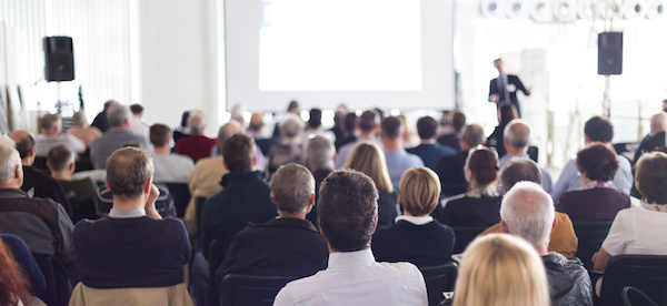 Speaker Giving a Talk at Business Meeting. Audience in the conference hall. Business and Entrepreneurship. Panoramic composition suitable for banners.