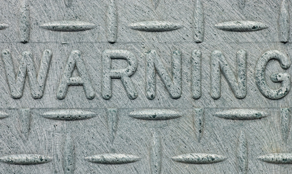 embossed warning sign on industrial background
