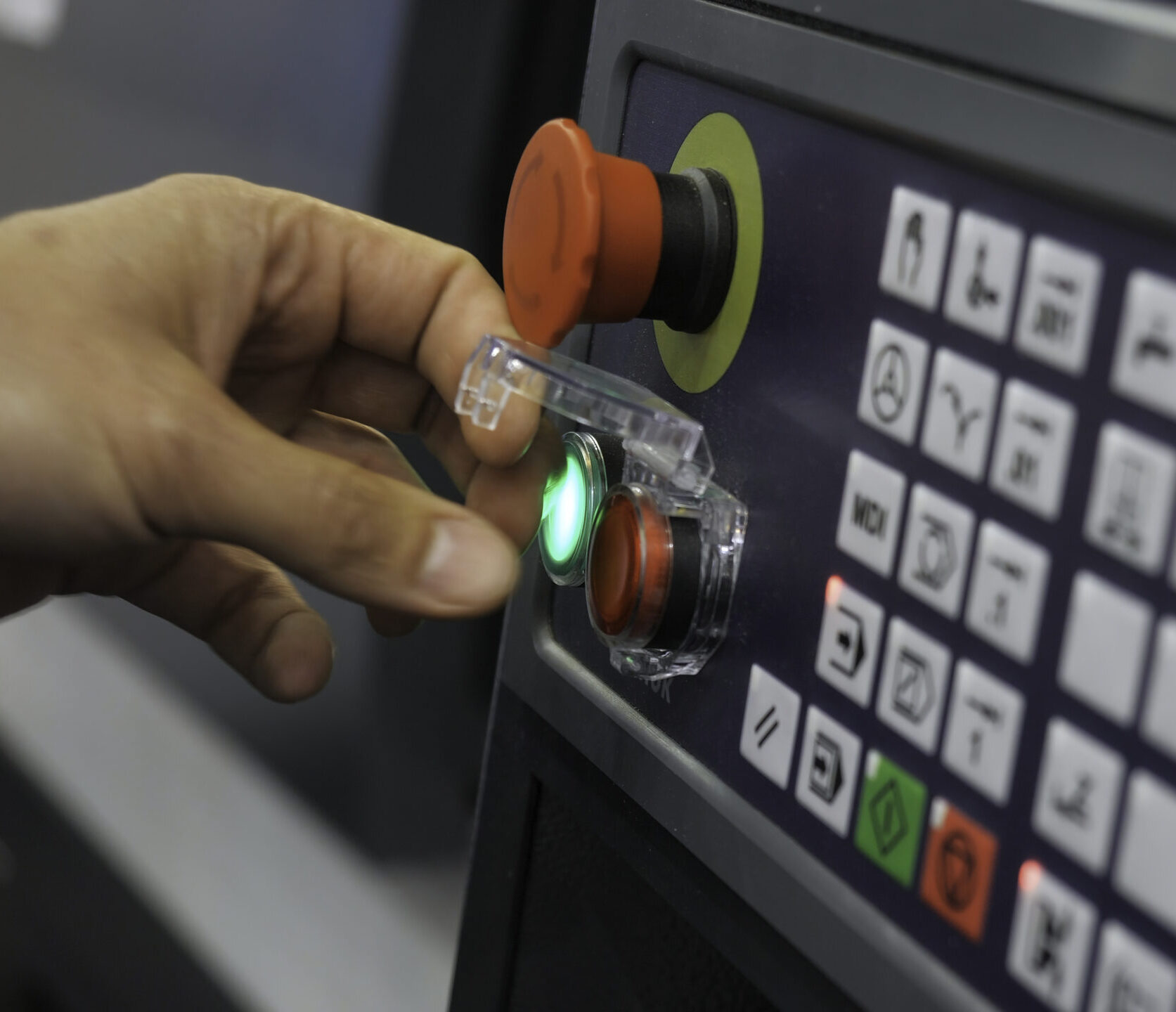 Industrial operator pressing a custom membrane switch control panel button